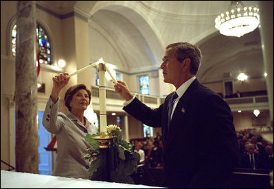President George W. Bush and First Lady Laura Bush light a candle at St. John Episcopal Church in Washington, D.C., during a private service of prayer and remembrance Wednesday morning, September 11, 2002.
