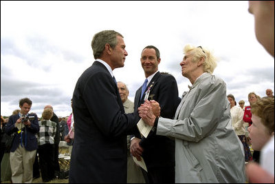 President George W. Bush talks to relatives of the victims from Flight 93 after laying a wreath at the crash site in Somerset County Pennsylvania on September 11, 2002.