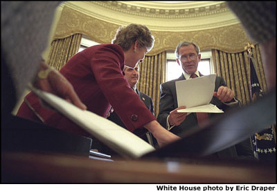 Created from a cacophony of opinions, details and revisions, an almost final version is reviewed by President Bush, Counselor Karen Hughes, Chief of Staff Andy Card and National Security Advisor Dr. Condoleezza Rice (holding the notebook, foreground) in the Oval Office, Thursday,Jan. 24. White House photo by Eric Draper
