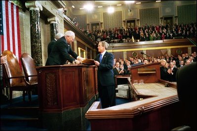President George W. Bush hands Vice President Dick Cheney and Speaker of the House Dennis Hastert (not pictured) a copy of his State of the Union Address upon his arrival to the House Chamber at the U.S. Capitol Tuesday, Jan. 28, 2003.