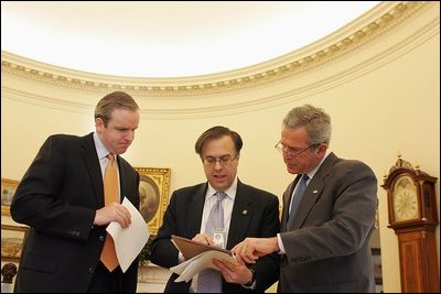 Advisors Dan Bartlett, left, and Mike Gerson work with President George W. Bush Tuesday, Feb. 1, 2005, in the Oval Office fine-tuning his State of the Union address scheduled to be delivered Wednesday night. 