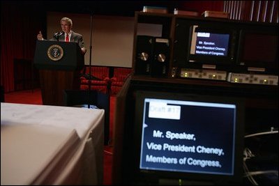 As teleprompters play out lines in the foreground, President George W. Bush stands at the podium in the Family Theater of the White House Tuesday, Feb. 1, 2005, during preparation for Wednesday's scheduled State of the Union address.