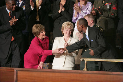 Mrs. Laura Bush and Lynne Cheney shake hands with Wesley Autrey during President Bush's State of the Union Address at the U.S. Capitol Tuesday evening, Jan. 23, 2007. "Three weeks ago, Wesley Autrey was waiting at a Harlem subway station with his two little girls, when he saw a man fall into the path of a train," said President Bush. "With seconds to act, Wesley jumped onto the tracks, pulled the man into the space between the rails, and held him as the train passed right above their heads. He insists he's not a hero. He says: 'We got guys and girls overseas dying for us to have our freedoms. We have got to show each other some love.' There is something wonderful about a country that produces a brave and humble man like Wesley Autrey."