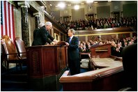 President George W. Bush hands Vice President Dick Cheney and Speaker of the House Dennis Hastert (not pictured) a copy of his State of the Union Address upon his arrival to the House Chamber at the U.S. Capitol Tuesday, Jan. 28, 2003. 