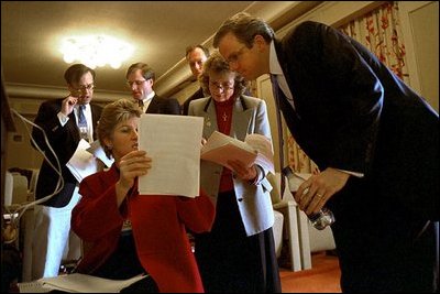 Advisor Karen Hughes reviews parts of the speech with White House Staff Secretary Harriet Miers and Director of Communications Dan Bartlett as White House speechwriters confer behind them during a rehearsal in the family theater of the White House Jan. 26, 2003.