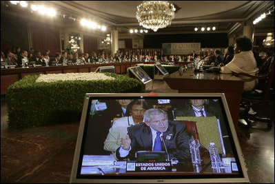 President George W. Bush and Secretary of State Condoleezza Rice are shown on a video monitor as the President speaks Friday, Nov. 4, 2005, during the opening session of the 2005 Summit of the Americas in Mar del Plata, Argentina.