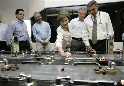 Laura Bush with President George W. Bush turns a knob during a tour of the operations center of the Panama Canal's Miraflores Locks in Panama City, Panama, Monday, Nov. 7, 2005. 