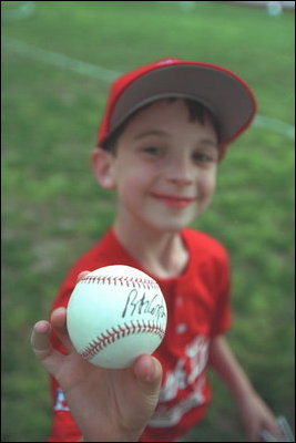 A Rockies player shows off his signed baseball from the afternoon during a tee-ball game on the South Lawn May 6, 2001.