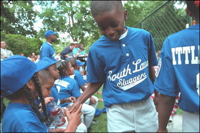 Players congratulate each other in the dugout during the second Tee Ball game on the South Lawn on Sunday, June 3, 2001.