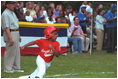A player rounds first base as Transportation Secretary Norman Mineta umpires the first base line during the second Tee Ball game on the South Lawn on Sunday, June 3, 2001.