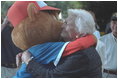 Barbara Bush, the President's mother, hugs the Little League mascot at game's end at the second Tee Ball game on the South Lawn on Sunday, June 3, 2001.