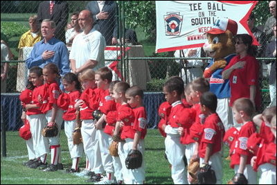 President George W. Bush and Cal Ripken stand for the singing of the national anthem during the opening ceremony of the first game of the White House Tee Ball season Sunday, May 5, 2002. Mr. Ripken is serving as the honorary commissioner of the White House T-ball League.