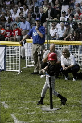 A little slugger from Kalamazoo, Mich., takes his hit under the expert gaze of Honorary Commissioner and Baltimore Orioles great Cal Ripken and Olympic Gold Medalist and Honorary Third Base Coach Dot Richardson during the last game of the White House South Lawn Tee Ball season Sunday, Sept. 7, 2003.