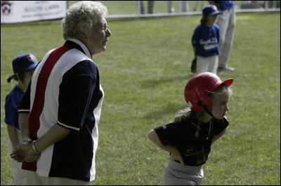 A runner with the Hamilton Little Lads of Hamilton, N.J., waits to make her next move with her honorary base coach Dolly White, former fielder with the Fort Wayne Daises and the Kenosha Comets, during the last game of the 2003 White House South Lawn Tee Ball season Sunday, Sept. 7, 2003. Ms. White played professional baseball with the All-American Girls Professional Baseball League Players Association, which operated from 1943 to 1954.