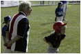 A runner with the Hamilton Little Lads of Hamilton, N.J., waits to make her next move with her honorary base coach Dolly White, former fielder with the Fort Wayne Daises and the Kenosha Comets, during the last game of the 2003 White House South Lawn Tee Ball season Sunday, Sept. 7, 2003. Ms. White played professional baseball with the All-American Girls Professional Baseball League Players Association, which operated from 1943 to 1954.