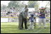 President George W. Bush and Honorary Commissioner Cal Ripken present a little leaguer with a warm congratulations and an autographed baseball after playing the last game of the 2003 White House South Lawn Tee Ball season Sunday, Sept. 7, 2003.