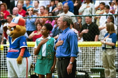 President Bush starts off the first game of the 2004 White House Tee Ball season with the pledge of allegiance June 13, 2004. Standing with the President are members of Girl Scout Troop.