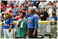 President Bush starts off the first game of the 2004 White House Tee Ball season with the pledge of allegiance June 13, 2004. Standing with the President are members of Girl Scout Troop.