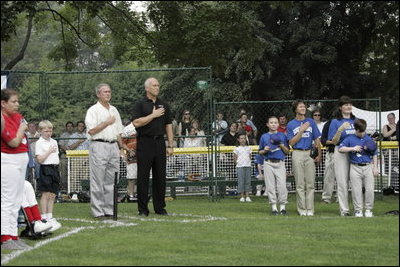 President George W. Bush stands with Cal Ripken Jr. for the National Anthem at Tee Ball on the South Lawn at the White House on Sunday July 11, 2004.
