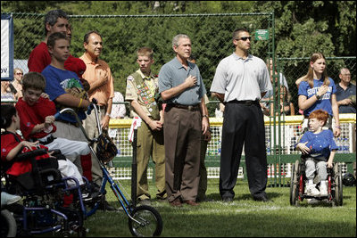 President George W. Bush listens to the National Anthem before a Tee Ball game on the South Lawn of the White House between the District 12 Little League Challengers from Williamsport, PA and the West University Little League Challengers from Houston, Texas on Sunday July 24, 2005.
