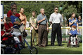 President George W. Bush listens to the National Anthem before a Tee Ball game on the South Lawn of the White House between the District 12 Little League Challengers from Williamsport, PA and the West University Little League Challengers from Houston, Texas on Sunday July 24, 2005.
