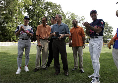 President George W. Bush laughs with Major League Baseball Hall of Fame players Ozzie Smith and Paul Molitor and former umpire Steve Palermo while congratulating Challenger Tee Ball players after a game on the South Lawn of the White House on Sunday July 24, 2005.