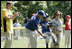 A player for the Shady Spring Little League Challenger Braves of Shady Spring W. Va., is helped around the bases Sunday, July 30, 2006, at the White House Tee Ball on the South Lawn game against the Thurmont Little League Civitan Club of Frederick Challengers of Thurmont, Md. 