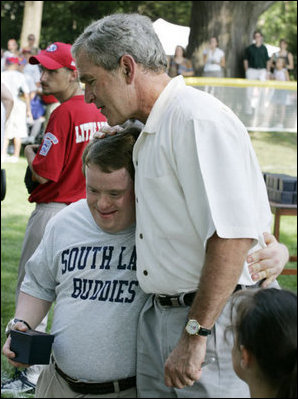 President George W. Bush embraces a South Lawn buddy volunteer Sunday, July 30, 2006, on the South Lawn of the White House at the conclusion of the Tee Ball on the South Lawn game between the Thurmont Little League Civitan Club of Frederick Challengers of Thurmont, Md., and the Shady Spring Little League Challenger Braves of Shady Spring, W. Va.