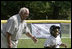 Hall of Fame baseball manager Tommy Lasorda urges on a player from the Wrigley Little League Dodgers of Los Angeles, as he runs for home against the Inner City Little League of Brooklyn, N.Y., Sunday, July 15, 2007, during the White House Tee Ball Game celebrating the legacy of Jackie Robinson on the South Lawn of the White House. Brooklyn and Los Angeles represent the two home cities of Robinson’s team.