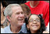 President George W. Bush poses for a photo with a fan in the stands Monday, June 30, 2008, during the opening game of the 2008 Tee Ball season between the Cramer Hill Little League Red Sox of Camden, N.J., and the Jose M. Rodriguez Little League Angels of Manatí, Puerto Rico, on the South Lawn of the White House.