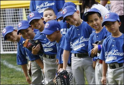 Players of the Jose M. Rodriguez Little League Angels of Manatí, Puerto Rico, all look over toward President George W. Bush as he welcomes everyone to the 2008 Tee Ball on the South Lawn Season Opener Monday, June 30, 2008, on the South Lawn of the White House.