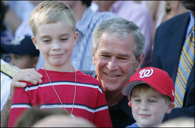  President George W. Bush poses for photos with two youngsters at the Tee Ball on the South Lawn: A Salute to the Troops game Sunday, Sept. 7, 2008, played by the children of active-duty military personnel.
