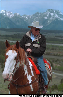 Framed by the snow-capped peaks of the Grand Teton Mountain Range, Vice President Cheney tours the countryside on horseback with his family, who are not pictured. White House photo by David Bohrer.