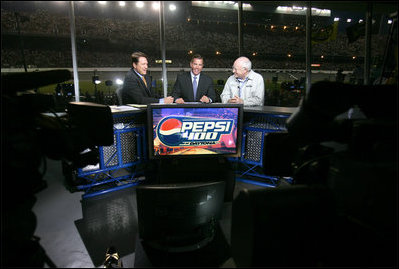 Vice President Dick Cheney talks with Chris Myers, left, and Jeff Hammond, center, of Fox Sports Network, Saturday, July 1, 2006, during a live TV interview held during the 2006 Pepsi 400 NASCAR race at Daytona International Speedway in Daytona, Fla.