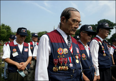 Members of the Korean War Veterans Association bow their heads during the invocation at the 2006 Korean War Veterans Armistice Day Ceremony, Thursday, July 27, 2006, at the Korean War Memorial in Washington, D.C.