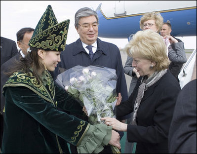 A Kazakh woman adorned in ceremonial dress welcomes Mrs. Lynne Cheney to Astana, Kazakhstan, with a bouquet of flowers, Friday, May 5, 2006.