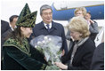 A Kazakh woman adorned in ceremonial dress welcomes Mrs. Lynne Cheney to Astana, Kazakhstan, with a bouquet of flowers, Friday, May 5, 2006.