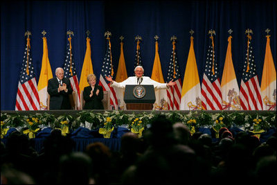 Pope Benedict XVI, joined on stage by Vice President Dick Cheney and Mrs. Lynne Cheney, gestures to the faithful Sunday, April 20, 2008 at a farewell ceremony for the Pope at John F. Kennedy International Airport in New York.