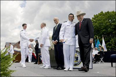 Vice President Dick Cheney poses for a photograph with a U.S. Coast Guard Academy graduate, Wednesday, May 21, 2008, during commencement exercises in New London, Conn.