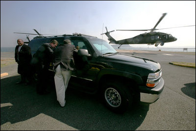 U.S. Secret Service agents take cover behind an S.U.V. as the helicopter carrying Vice President Dick Cheney approaches for a landing at Yokosuka Naval Base in Japan, Feb. 21, 2007. White House photo by David Bohrer