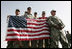 U.S. troops hold the American flag as they await Vice President Dick Cheney's arrival to a rally Tuesday, March 18, 2008 at Balad Air Base, Iraq.