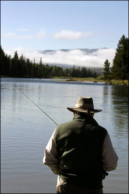Clouds hang along the horizon as Vice President Dick Cheney casts a line in the waters of the Snake River in Idaho.
