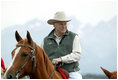 Framed by the snow-capped peaks of the Grand Tetons, Vice President Cheney tours the Wyoming countryside on horseback.
