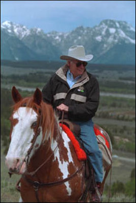 Framed by the snow-capped peaks of the Grand Teton Mountain Range, Vice President Cheney tours the countryside on horseback with his family, who are not pictured.