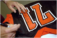 Vice President Dick Cheney autographs jerseys for football players from his alma mater, Natrona County High School in Casper, Wyo., Sept. 20, 2002.