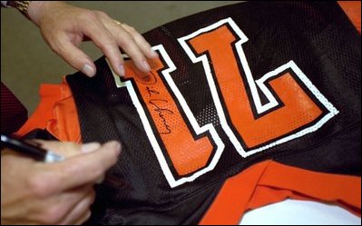 Vice President Dick Cheney autographs jerseys for football players from his alma mater, Natrona County High School, in Casper, Wyo., Sept. 20, 2002.