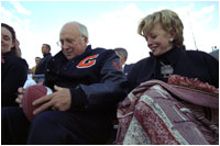 Vice President Dick Cheney signs a football for a Natrona County High School student while watching the school's homecoming game with his high school sweetheart, Lynne Cheney, in Casper, Wyo., Sept. 20, 2002. 