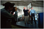 Sharing the stage with artist Chad DuLac, Vice President Dick Cheney displays a drawing of himself while aboard the USS Stennis Aircraft Carrier March 15.