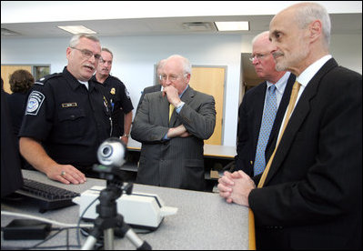 Vice President Dick Cheney, Senator Saxby Chambliss, and Department of Homeland Security Secretary Michael Chertoff listen as a U.S. Customs and Border Protection agent shows off some of the technology being used to train law enforcement personnel at the Federal Law Enforcement Training Center in Glynco, Georgia, May 2, 2005. The Vice President toured the facility, which provides training to more than 80 federal agencies, in addition to state and local police. The facility is the largest law enforcement training establishment in the country and graduates over 50,000 students annually.