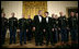 President George W. Bush and President Nicolas Sarkozy of France stand on stage with the Army Chorus in the East Room of the White House Tuesday, Nov. 6, 2007, following the after-dinner performance by the 22-member group.